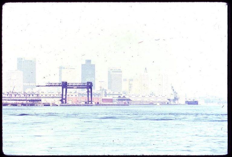A city skyline is partly obscured by thick haze caused by air pollution.